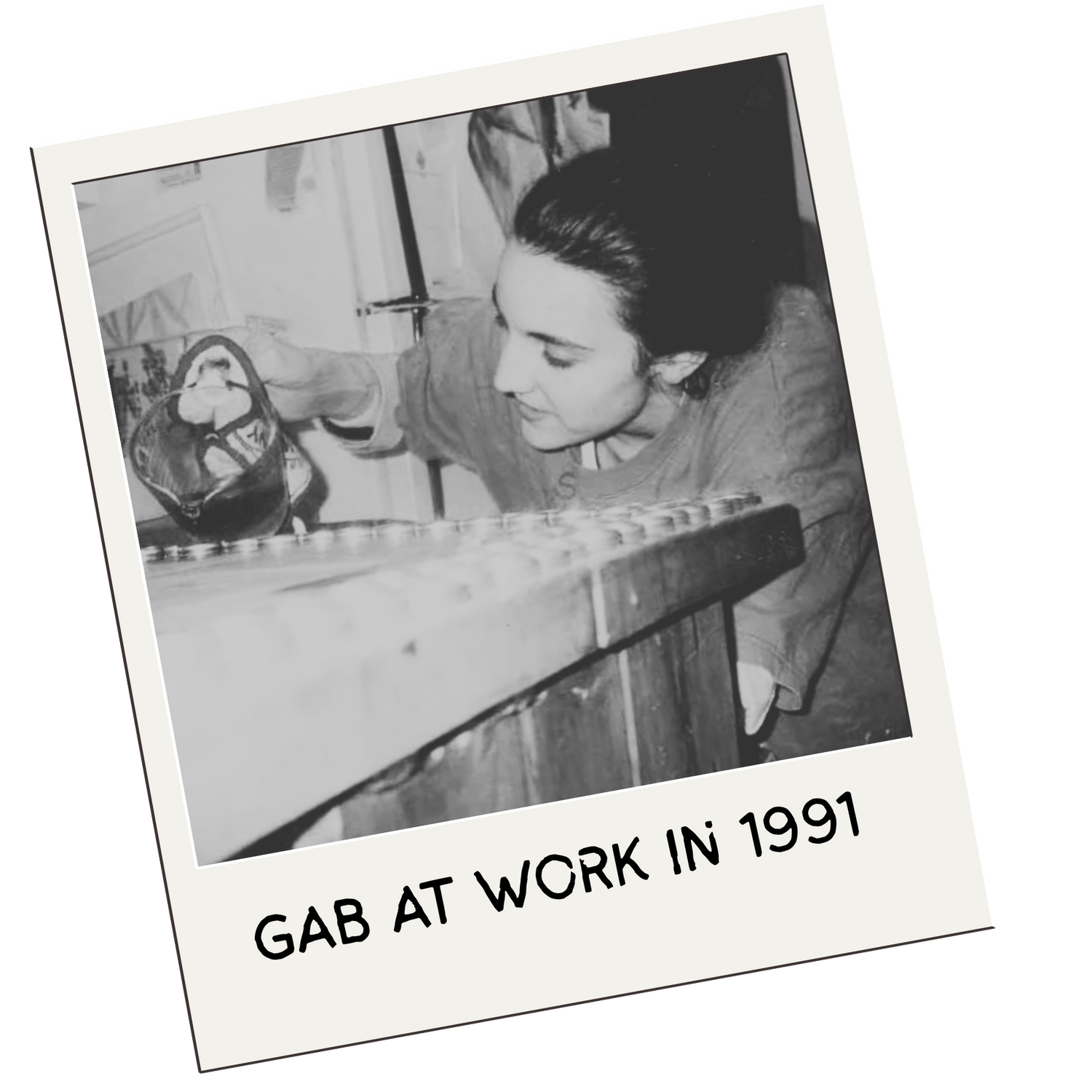 Black and white photo of a person at work with text 'GAB AT WORK IN 1991' on a white border