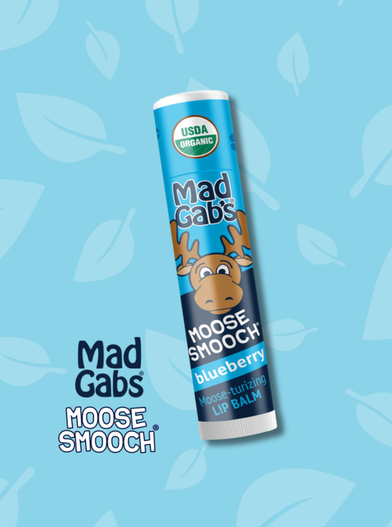 Mad Gabs Moose Smooch blueberry lip balm on a blue background with leaf patterns